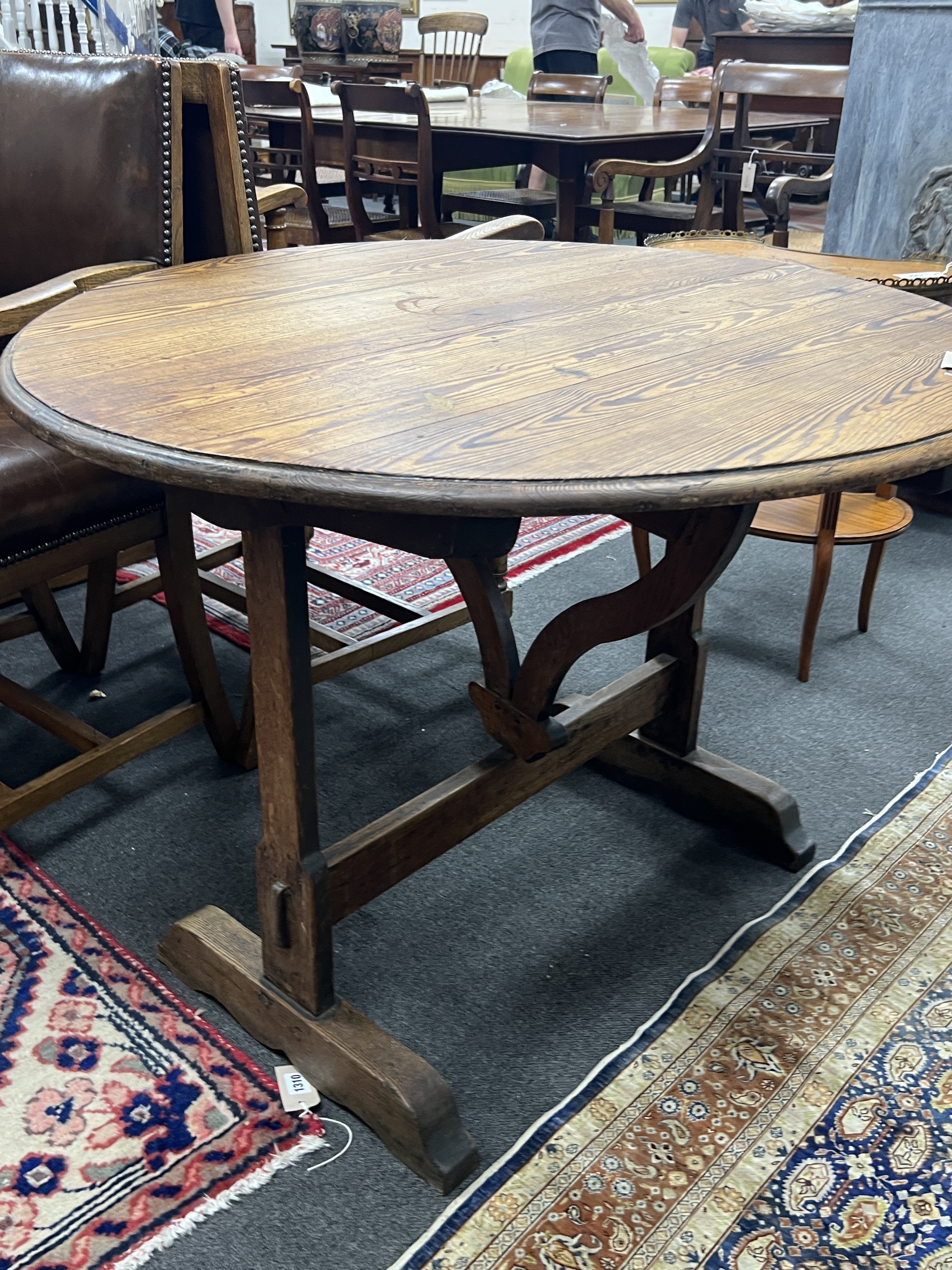 A 19th century French oval oak and pine tilt top folding table, width 90cm, depth 100cm, height 72cm